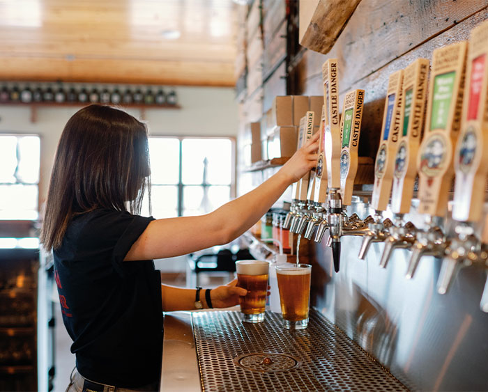Bartender pouring a beer at the bar.